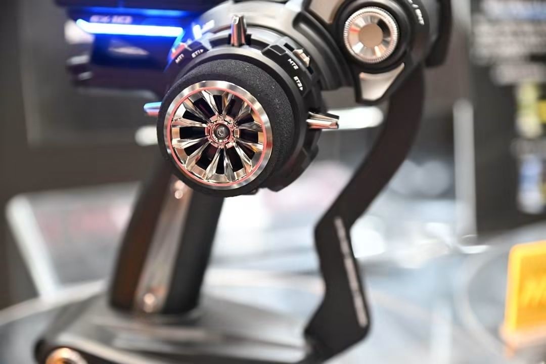 Close-up of a black radio-control transmitter with a chrome steering wheel