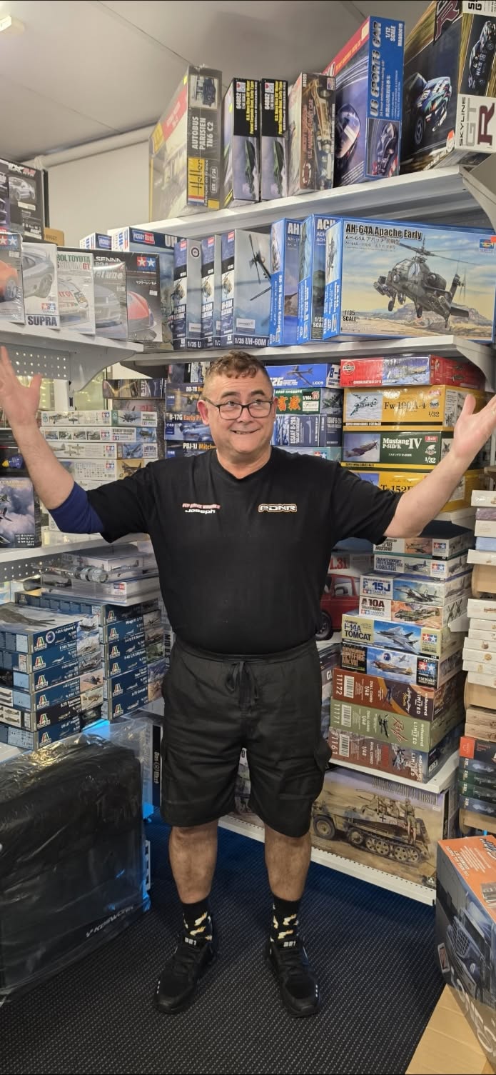 Shelves stacked with boxed model kits inside the Fly Drive Hobbies shop